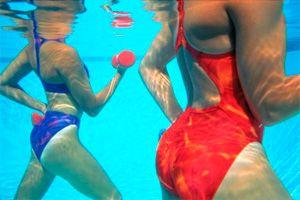 Kvindelige kroppe under vand i poolen