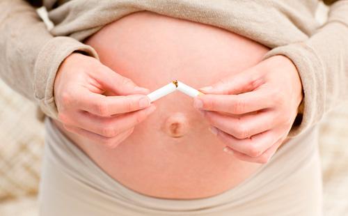 La ragazza incinta rompe una sigaretta