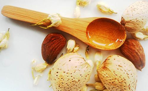 Květiny, ořechy a zlaté máslo v dřevěnou lžící