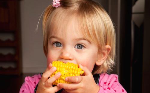 Vaaleanpunainen tyttö rakastaa maissia