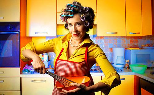 Žena v natáčky na vlasy připravuje večeři pro domácnost