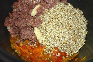 يتم وضع الخضروات واللحوم والحبوب في طبقات في وعاء متعدد الطناجر