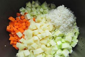 Тиквички и моркови, нарязани на кубчета и шепа ориз в купа за мултикукър