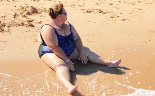 Bbw sedí na písku na pláži