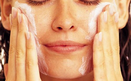 La dona es frega la massa proteica a les galtes