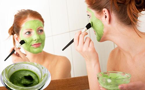 Frau trägt grüne Vitaminzusammensetzung mit einem Pinsel auf