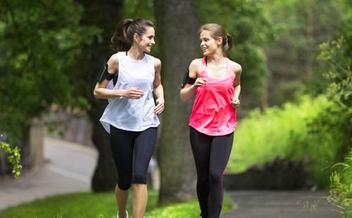 Két lány nevetve és beszélgetni futás közben