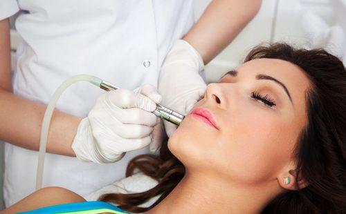 Kosmetolog opererer en kvinde med en laser