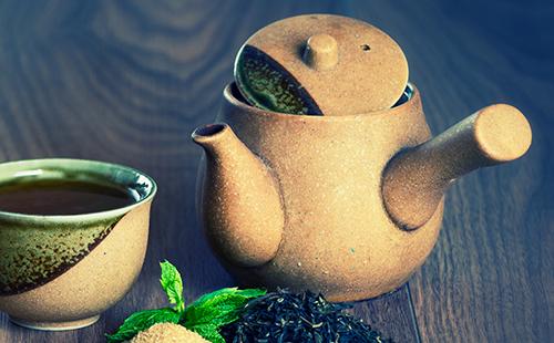 Černý čaj s mátou a hnědým cukrem v keramické sadě
