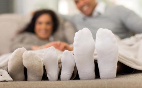 Äiti, isä ja vauva valkoisissa sukeissa