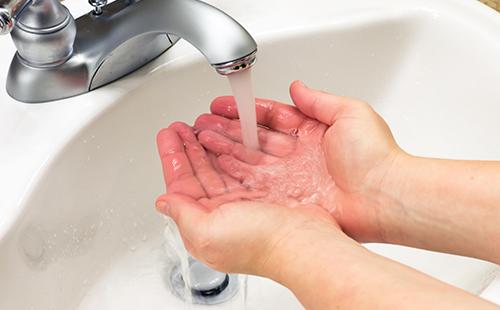 Les mains mouillées sous le robinet