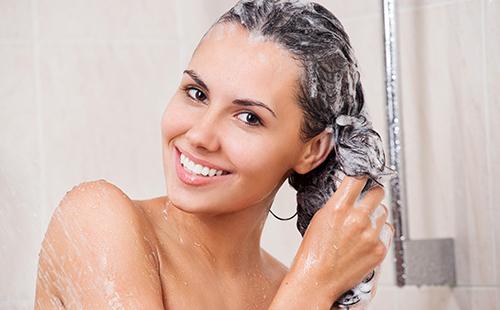 La donna si lava i capelli con lo shampoo
