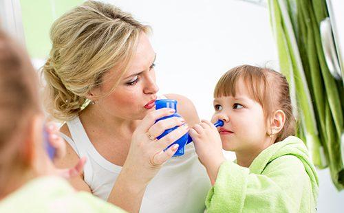 La mamma aiuta il bambino a lavarsi il naso