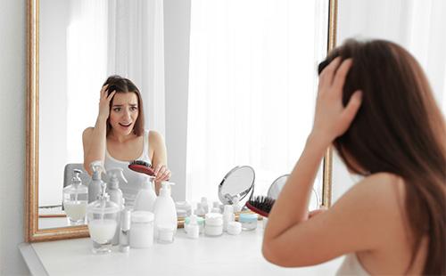 Жена, гледаща се в огледалото