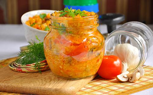 Konservuotos daržovės stiklainyje su pomidorais ir žolelėmis