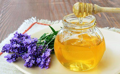Purkki hunajaa ja oksa tuoksuvaa laventelia