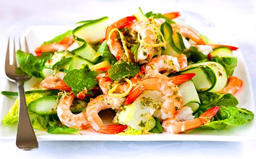 Salát s krevetami, okurkami a bylinkami na talíři
