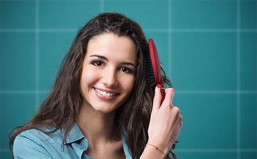 Mladá žena česání vlasy