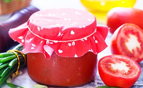 Ang tomato paste sa isang garapon at hiniwang mga kamatis