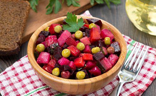 Rote-Bete-Wurzeln Salat mit Erbsen in einer hölzernen Schüssel