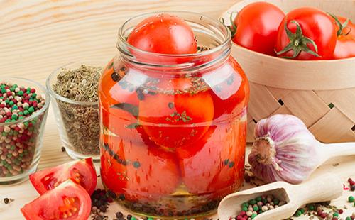In Büchsen konservierte Tomaten in einem Glas mit Knoblauch und Gewürzen