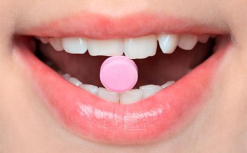 Růžový tablet v ústech