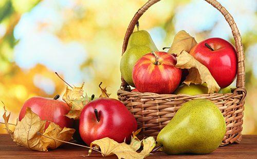 Korb mit roten Äpfeln und Birnen