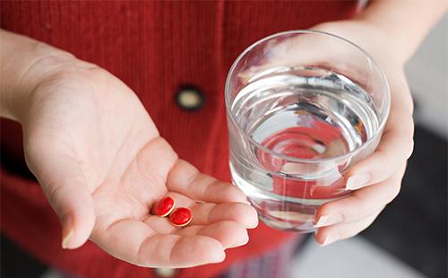 Červené pilulky v dlani