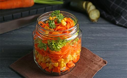 Salat mit Karotten und Erbsen in einem Glas