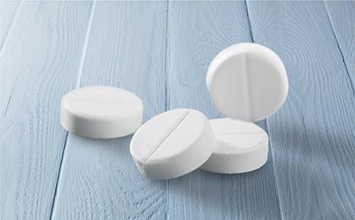 Valkoisia pillereitä pöydällä