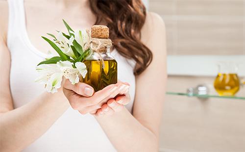 Olivový olej ve sklenici v rukou dívky