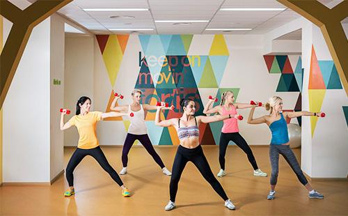 النساء ممارسة اللياقة البدنية في صالة الألعاب الرياضية