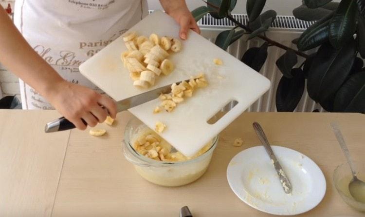 Smulkiai supjaustytus bananus į sviesto ir kondensuoto pieno mišinį.