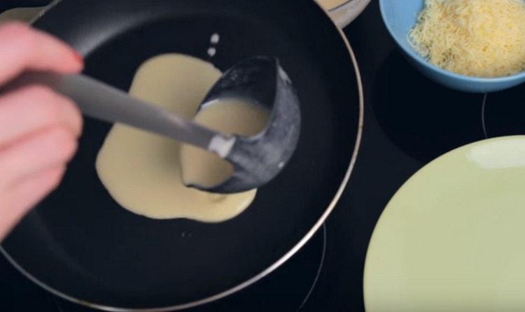 Изсипете тестото в тигана и го завъртете, оформяйки палачинка.