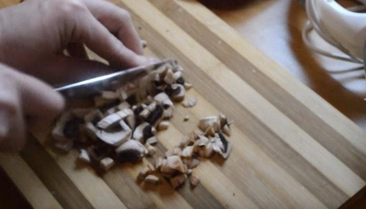 Zum Füllen von Pfannkuchenpilzen die Pilze fein hacken (Sie können sogar Austernpilze verwenden).