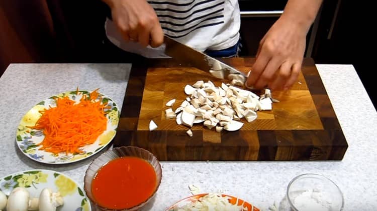 Fügen Sie einige Karotten zur Füllung hinzu und hacken Sie die Pilze.