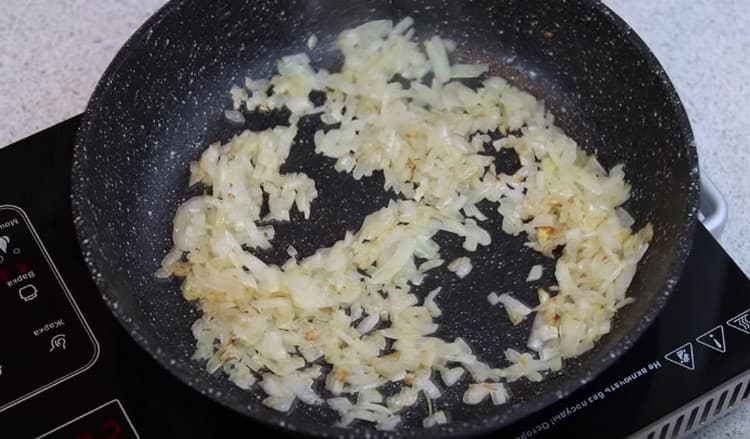 Τρίψτε και ελαφρώς τηγανίζετε τα κρεμμύδια σε μια κατσαρόλα.