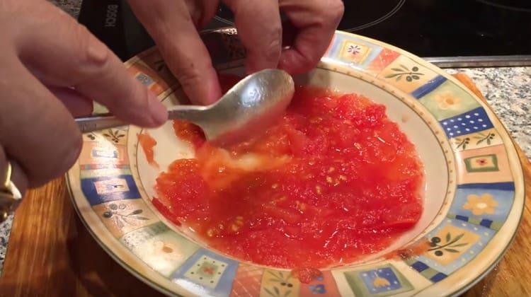 Die eingelegte Tomate mit einem Löffel kneten.