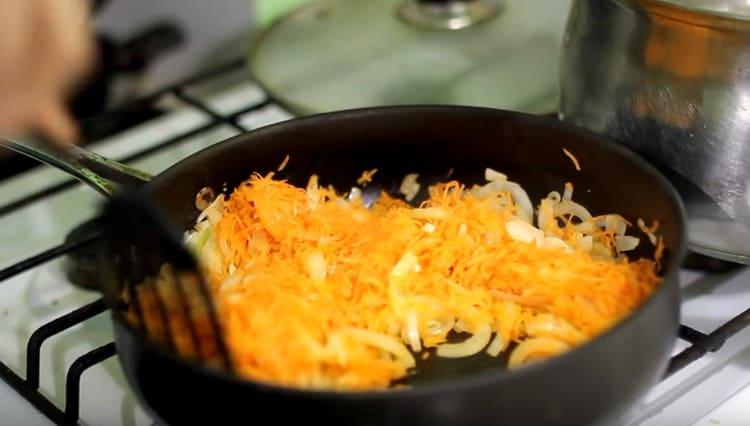 Fügen Sie die auf einer groben Reibe geriebenen Karotten der Zwiebel und dem Passanten hinzu.