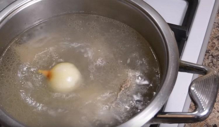 Aggiungi la cipolla al brodo bollito.