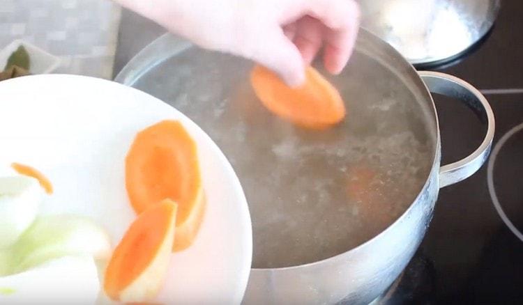 Tagliare le carote a pezzi grossi e aggiungere alla padella la carne.