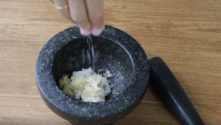In un mortaio, mettere lo strutto tritato, l'aglio, il sale.