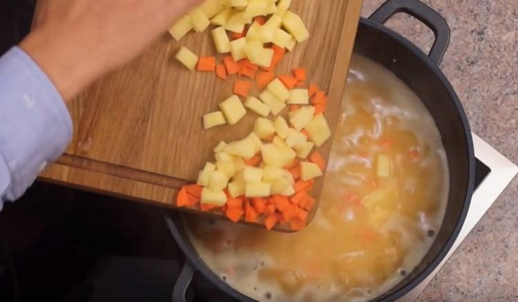 Добавете моркови и картофи към супата.