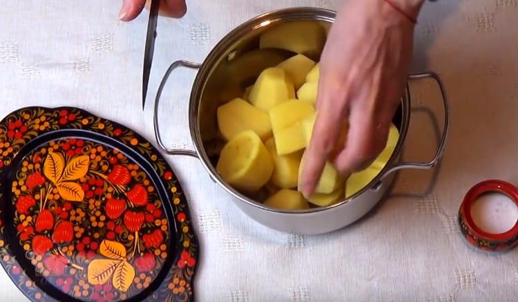 Обелете и нарежете картофите на едри парчета.