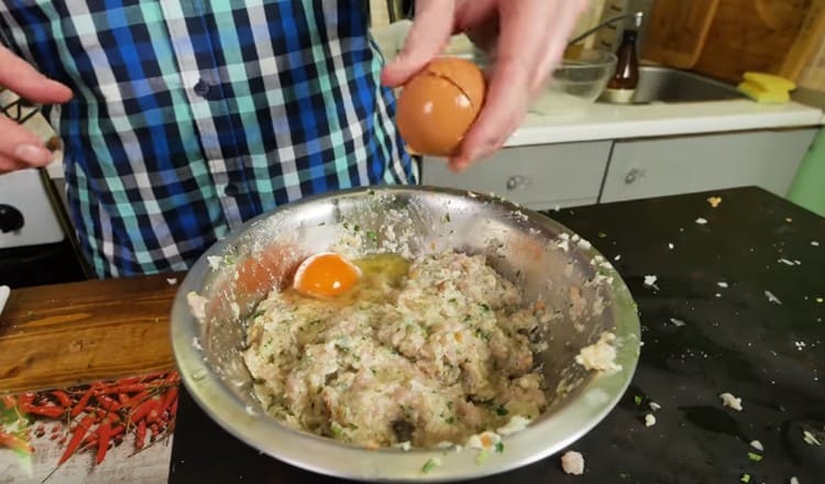 طرق البيض في وعاء باللحم المفروم ، امزجي.