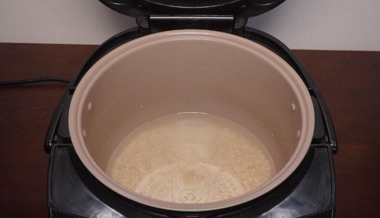 Изсипете вода в купата на мултикуксора, ако желаете, веднага изсипете зърнени култури в нея.