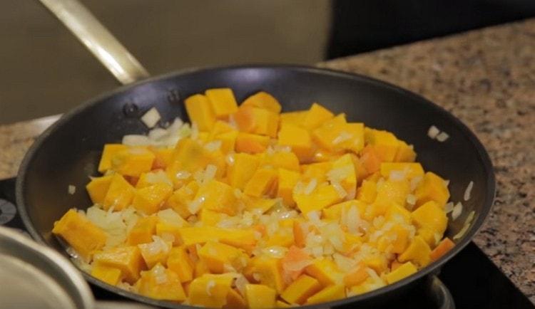 Cipolle, carote e pezzi di zucca vengono fatti passare in una padella.
