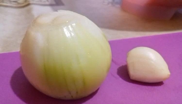 Sbucciare la cipolla e l'aglio.