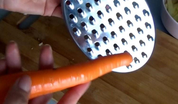 Drei Karotten auf einer groben Reibe.