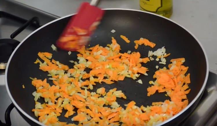 Fügen Sie Karotten der Zwiebel hinzu und bereiten Sie das Braten vor.